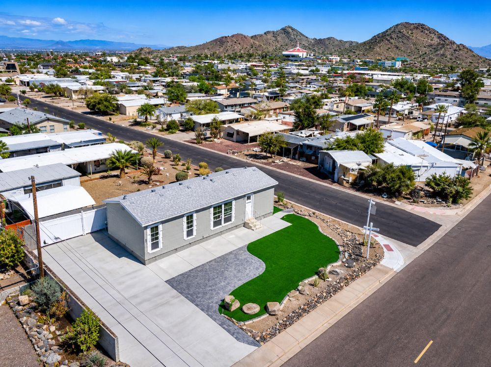 Aerial view of corner lot home for sale in Phoenix AZ with large driveway and landscaped yard at 13004 N 19th Pl